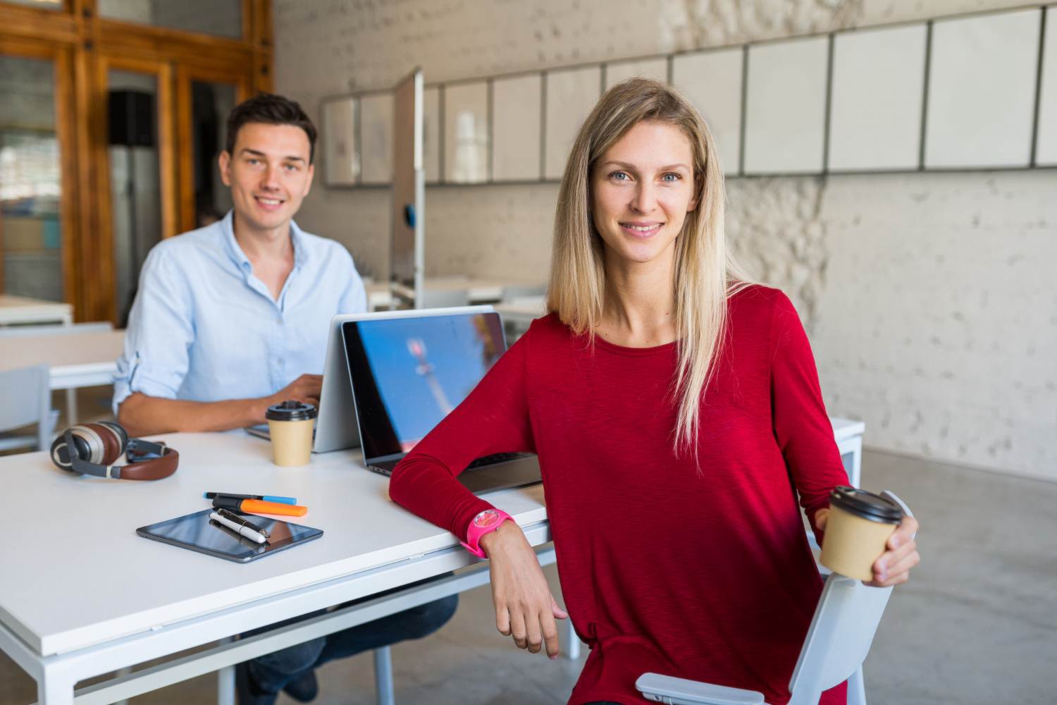 modern young people sitting at table, working at laptop in co working office